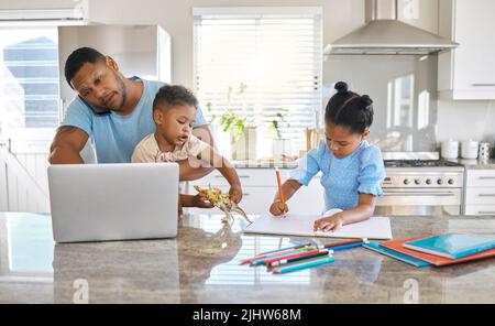 Jeder hat etwas zu tun. Ein junger Vater arbeitet, während er sich zuhause um Hi-Kinder kümmert. Stockfoto