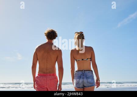 Ein junges Paar, das den Blick auf das Meer genießt. Stockfoto