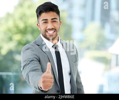 Du hast meine volle Unterstützung bekommen. Ein Porträt eines hübschen jungen Geschäftsmannes, der sich in seinem Büro um einen Händedruck streckte. Stockfoto