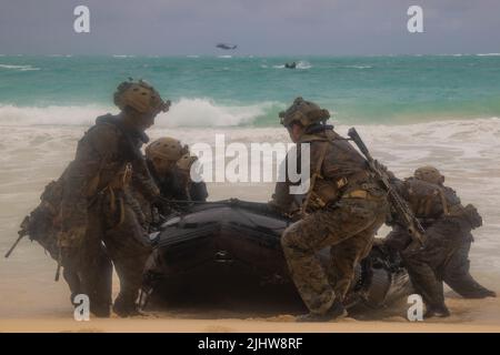 MARINE CORPS TRAINING AREA BELLOWS, Hawaii (18. Juli 2022) US-Marines mit 3. Aufklärungsbataillons, 3. Marine Division und australischen Soldaten ziehen ein Kampfflugzeuge mit Kautschuk-Raiding am Strand für helo-Cast-Training während des Rim of the Pacific (RIMPAC) 2022 im Marine Corps Training Area Bellows, Hawaii, 18. Juli. 26 Nationen, 38 Schiffe, vier U-Boote, mehr als 170 Flugzeuge und 25.000 Mitarbeiter nehmen vom 29. Juni bis zum 4. August an RIMPAC in und um die Hawaii-Inseln und Südkalifornien Teil. Die weltweit größte internationale maritime Übung, RIMPAC bietet ein U Stockfoto
