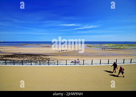 Whitley Bay Promenade an einem sonnigen Tag am Strand mit Spaziergängern und der Nordsee und einem tiefblauen Himmel mit Zirruswolke Stockfoto