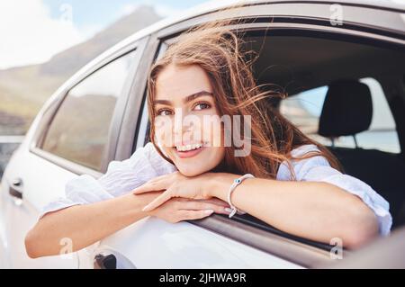 Was gibt es Schöneres, als zu reisen. Eine schöne junge Frau genießt eine abenteuerliche Fahrt im Auto. Stockfoto