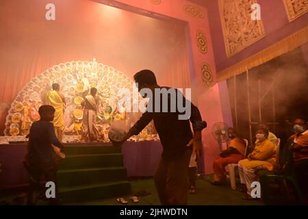 Howrah, Westbengalen, Indien -13. Oktober 2021 : Hindu-Anhänger tanzen Dhunuchi naach, vor der Göttin Durga als Ritual, während Dhaakis Dhaak spielen Stockfoto