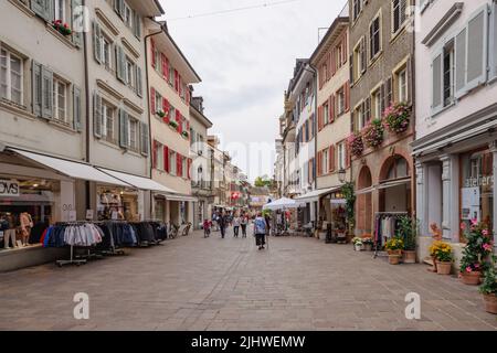 Menschen und Touristen wandern durch die alten engen Gassen und Gassen in Rheinfelden. Stockfoto