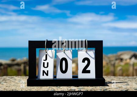 Jun 02 Kalenderdatumstext auf Holzrahmen mit verschwommenem Hintergrund des Ozeans. Kalenderdatum Konzept. Stockfoto