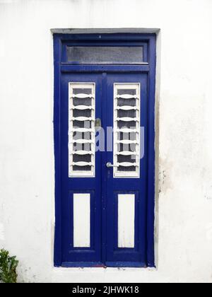 Blaue Tür an der weißen Wand Stockfoto