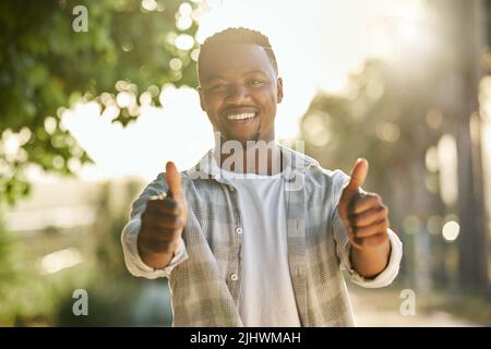 Mutter Natur gibt mir alles, was ich brauche. Ein junger Mann gibt einen Daumen nach oben auf einem Bauernhof. Stockfoto