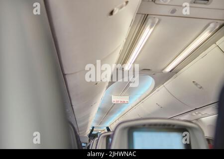 Bild des Flugzeugscreengeräts für Unterhaltung für den Passagier zuschneiden. Fliegen mit dem Flugzeug. Reisekonzept. Stockfoto