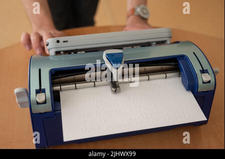 Blinder Mann mit Brailleschrift-Schreibmaschine. Stockfoto