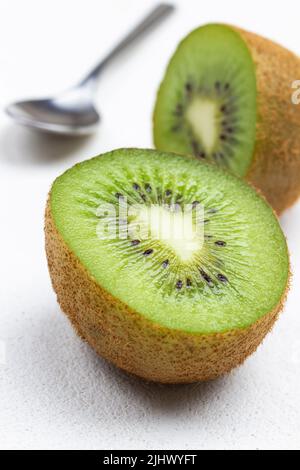 Zwei Kiwi-Hälften und Löffel. Nahaufnahme. Draufsicht. Weißer Hintergrund Stockfoto
