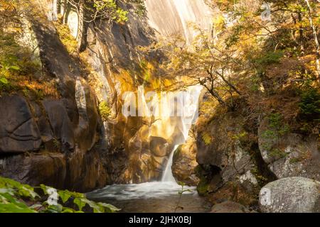 Wasserfall im Shosenkyo-Tal bei Herbstlaub Stockfoto