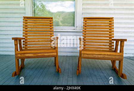 Zwei Schaukelstühle aus Holz auf einer Veranda aus weißem Holz Stockfoto