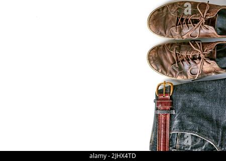 Stylische Shabby Vintage braune Lederschuhe und schwarze Jeans mit Gürtel auf weißem Hintergrund. Lifestyle und Mode. Draufsicht mit Kopierbereich Stockfoto