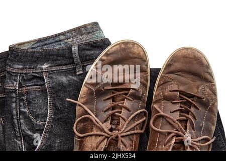 Stylische Shabby Vintage braune Lederschuhe und schwarze Jeans auf weißem Hintergrund. Lifestyle und Mode. Draufsicht mit Kopierbereich Stockfoto