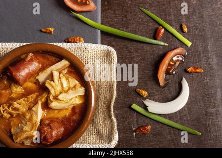 Typische spanische Küche Tapa callos, mit Chorizo ​​and mehrere seiner Zutaten auf der Seite auf einem Holz-und Schiefer-Hintergrund Stockfoto