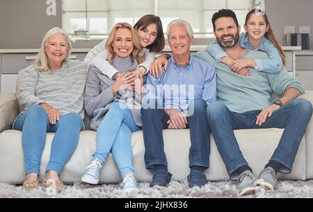 Der ultimative Dreh. Eine Familie, die sich zu Hause auf einem Sofa verbindet. Stockfoto