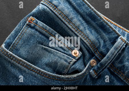 Ökologische blaue Jeans auf dunklem Hintergrund. Umweltfreundliches Bekleidungskonzept Stockfoto