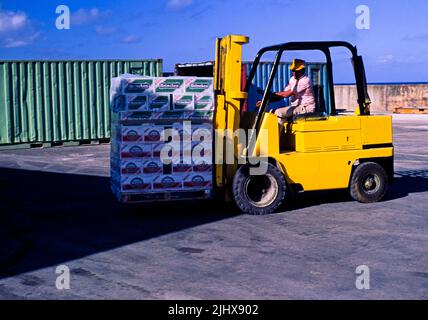 Gabelstapler, der Bierkisten am Kai am Dock, Cayman Brac, Cayman Islands, West Indies c 1990 transportiert Stockfoto
