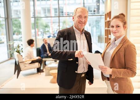 Älterer Geschäftsmann als Chef und junger Kollege als Auszubildender im Büro Stockfoto