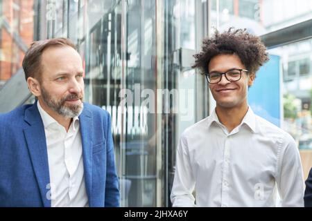 Älterer Geschäftsmann und junger Startup-Gründer als Geschäftspartner vor dem Bürogebäude Stockfoto