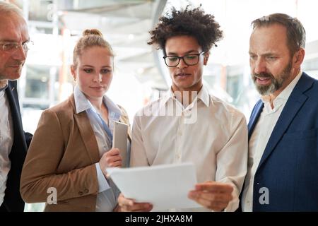 Mitarbeiter und Berater des Business-Start-up-Teams prüfen einen Jahresbericht oder eine Bilanz Stockfoto