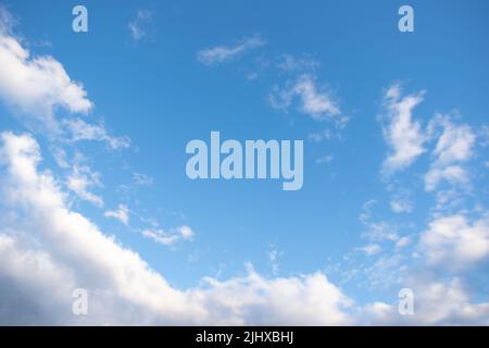 Blauer Himmel Hintergrund mit weißen flauschigen Cumulus Wolken. Panorama von weißen, flauschigen Wolken am blauen Himmel. Wunderschöner, riesiger blauer Himmel mit erstaunlichen verstreuten Stockfoto
