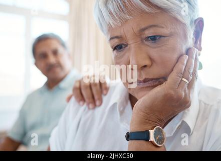 Ein unterstützender Partner ist Gold wert. Ein älterer Mann tröstet seine traurige Frau zu Hause. Stockfoto