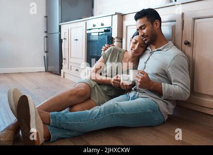 Du bist mein Zufluchtsort während der Stürme des Lebens. Ein junges Paar, das zu Hause zusammen eine Tasse Kaffee trinkt. Stockfoto