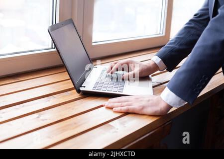 Geschäftsmann, der mit einem Laptop am Tisch arbeitet. Loft-Büro, Erforschung neuer Geschäftsstrategie, Hände aus nächster Nähe Stockfoto