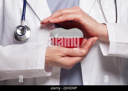 Polnischer Arzt mit Herz und Flagge von Polen Hintergrund. Healthcare, Charity, Versicherung und Medizin Konzept Stockfoto