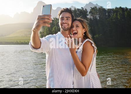 Weve bekam eine Überraschung. Ein junges Paar, das ein Selfie machte, nachdem es sich verlobt hatte. Stockfoto