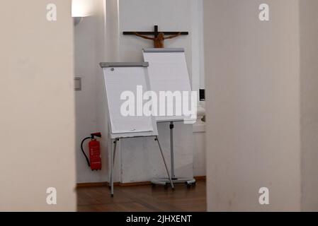 München, Deutschland. 21.. Juli 2022. Flipcharts stehen während der Pressekonferenz der Erzdiözese München und Freising vor einem Kreuz, um den Jahresabschluss 2021 und den Haushaltsplan 2022 vorzustellen. Rund ein halbes Jahr nachdem ein Gutachten zu Misshandlungen in der Erzdiözese München und Freising Schlagzeilen machte, legt die Erzdiözese ihr Budget für das laufende Jahr vor. Quelle: Angelika Warmuth/dpa/Alamy Live News Stockfoto