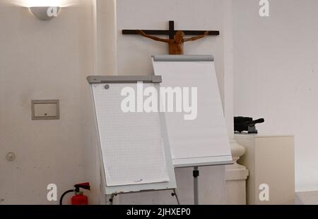 München, Deutschland. 21.. Juli 2022. Flipcharts stehen während der Pressekonferenz der Erzdiözese München und Freising vor einem Kreuz, um den Jahresabschluss 2021 und den Haushaltsplan 2022 vorzustellen. Rund ein halbes Jahr nachdem ein Gutachten zu Misshandlungen in der Erzdiözese München und Freising Schlagzeilen machte, legt die Erzdiözese ihr Budget für das laufende Jahr vor. Quelle: Angelika Warmuth/dpa/Alamy Live News Stockfoto