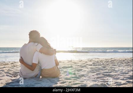 Sich Zeit für diese besonderen Momente zu nehmen. Ganzkörperaufnahme eines liebevollen jungen Paares, das einen intimen Moment am Strand teilt. Stockfoto