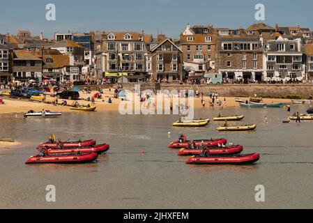 St Ives, Cornwall, England, Großbritannien. 2022. St Ives beliebter Badeort in Cornwall. Fahren Sie selbst rote aufblasbare Boote in flachem Wasser. Stockfoto