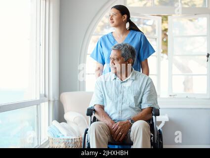 Ein hübscher älterer Mann und seine Krankenschwester im Altersheim. Stockfoto