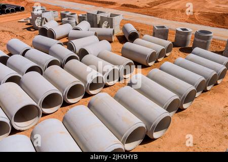Für den Bau von Entwässerungssystemen ist es erforderlich, dass große Zementabflussrohre in Industriegebäuden installiert werden Stockfoto