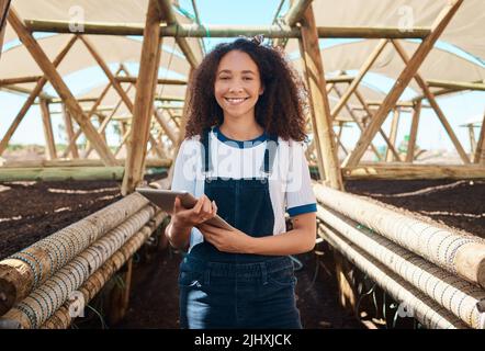 Ich halte die gesamte Erntepflege auf digitalen Aufzeichnungen. Porträt einer jungen Frau, die auf einem Bauernhof mit einem digitalen Tablet arbeitet. Stockfoto