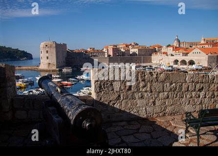 Dubrovnik, Kroatien. Blick über die Altstadt und den historischen Hafen vom Schloss mit Kanonenständer an der Stadtmauer. Blauer Himmel Hintergrund. Stockfoto