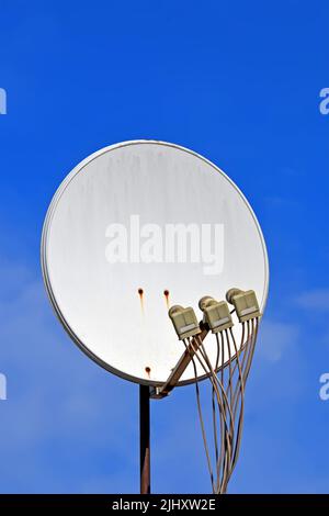 Multi-Feed-Satellitenantenne mit mehreren Feeds (Konverter) Nahaufnahme am blauen Himmel an sonnigen Tagen, moderne Telekommunikations-Vielfalt Stockfoto