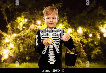 Junge mit Süßigkeiten und Taschenlampe an halloween Stockfoto