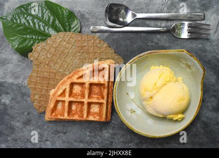Kugel Mango Bio-Eis in einer Keramikschale auf steingrauem Hintergrund Draufsicht Stockfoto