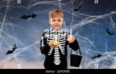 Junge mit Süßigkeiten und Taschenlampe an halloween Stockfoto