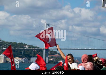 Istanbul, Türkei - 2022. Juli: Junges Mädchen mit türkischer Flagge und seiner Umgebung. Menschen, die die türkische Flagge auf dem Schiff schwenken. Stockfoto