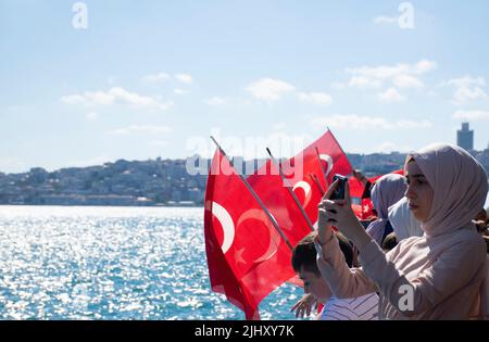 Istanbul, Türkei - Juli 2022: Flaggenschwingende Kinder und Mädchen, die neben ihnen Selfie machen. Istanbul Blick vom Schiff mit türkischer Flagge. Stockfoto
