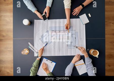 Geschäftsteam mit Blaupause arbeitet im Büro Stockfoto
