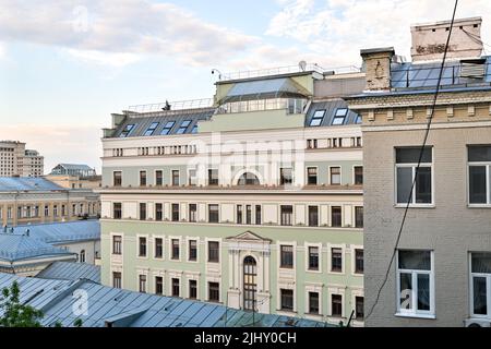 Blick auf benachbarte Häuser und das Stadtleben vom offenen Fenster aus. Stockfoto