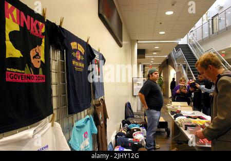 Kinky Friedman Gubernatorial Campaign Director of Merchandising Blake Waxler (links) wartet darauf, Kunden bei der Suche nach einer Auswahl an Stoßfängern, Knöpfen, Hüten, T-Shirts und anderen Kampagnenartikeln zu helfen, die am Donnerstag, den 2. November 2006, in der Smith Entrepreneur Hall auf dem Campus der Texas Christian University in Fort Worth zum Verkauf angeboten werden. Tarrant County, TX, USA. Friedman ist einer von zwei unabhängigen Kandidaten, die hoffen, den amtierenden republikanischen Gouverneur abzusetzen. Rick Perry wird der erste unabhängige Gouverneur des Lonestar State seit Sam Houston im Jahr 1859. (APEX MediaWire Foto von Timothy J. Jones) Stockfoto