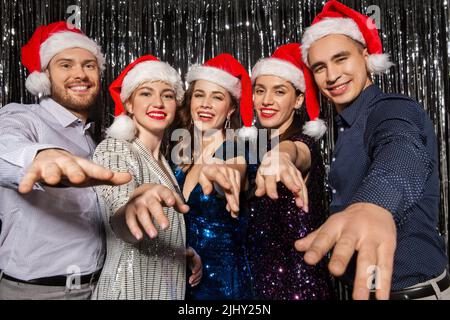 Gerne Freunde in santa Hüte auf Weihnachtsfeier Stockfoto