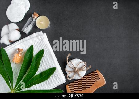 Kosmetik und Wellness-Accessoires auf betonem Hintergrund. Konzept der Gesichts- und Körperpflege. Handtuch, Haarbürste, ätherisches Öl. Flache Lay-Komposition. Umweltfreundlich Stockfoto